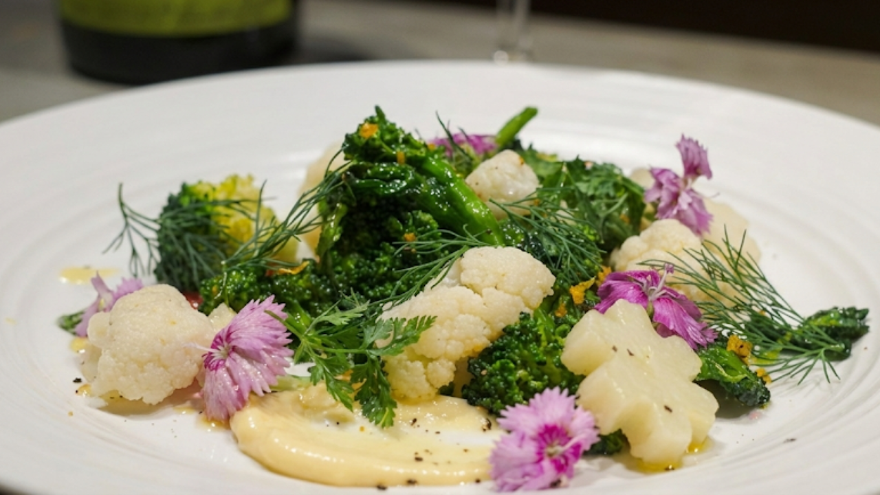 Colorful Gargouillou-style spring vegetable salad with edible flowers and herbs on a white plate