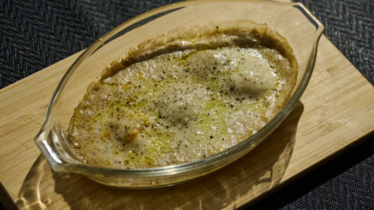 Truffle-scallop and mushroom gratin with golden brown cheese crust paired with white wine dinner scene