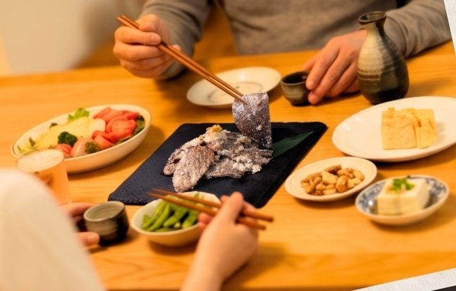 食卓でお酒とビーフズーシーを囲むふたり