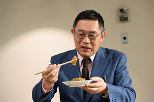 松前漬けを箸で持ち上げて味わう、松丸産直デパートのバイヤー